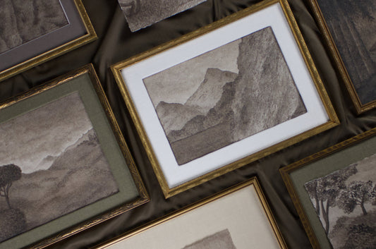framed vintage style watercolour paintings arranged on table